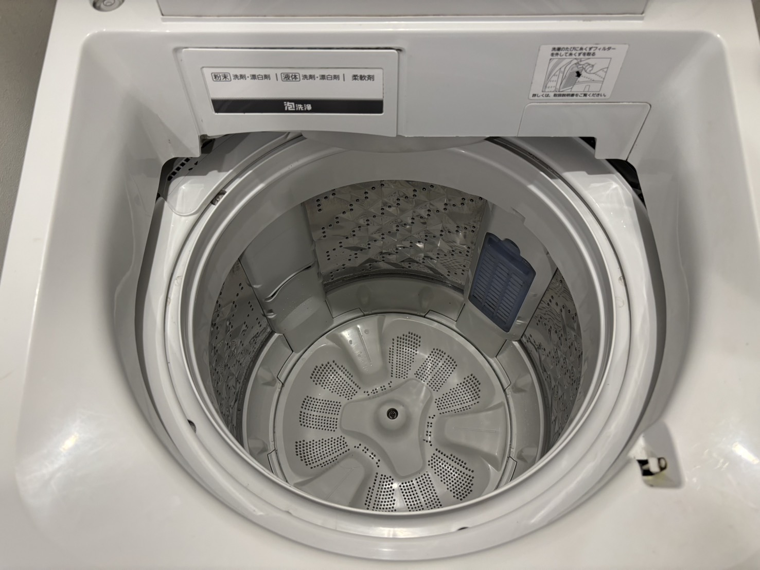 ふたを開けた縦型洗濯機の洗濯槽と回転羽根